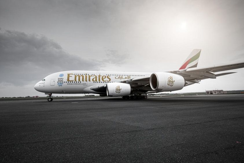 Lietadlo Emirates stojace na dráhe.