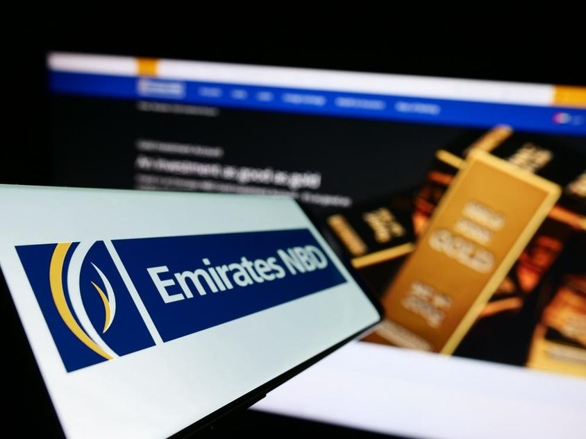 Emirates NBD felírat előtérben, háúl egy befektetési aranytömböt látni.