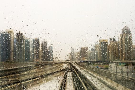 被雨水打湿的窗户外的摩天大楼景观。