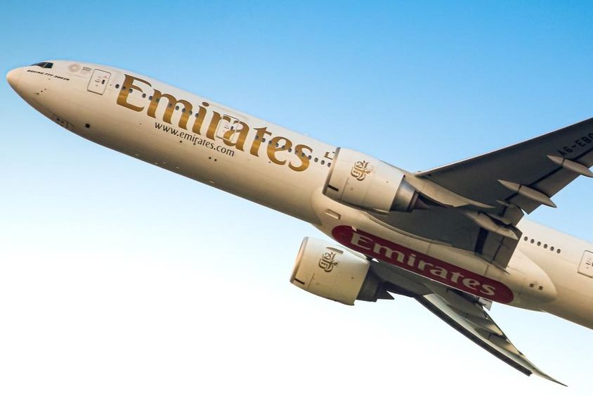 Emirates airplane in the sky, visible from below.