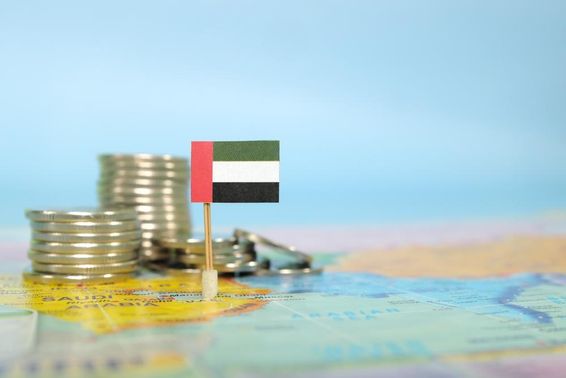 Egy térkép látható beletűzve egy UAE zászló, mellette aprópénz felstocolva.