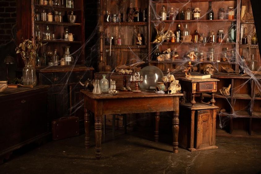A spooky room corner with cobwebs, skulls, bottles.