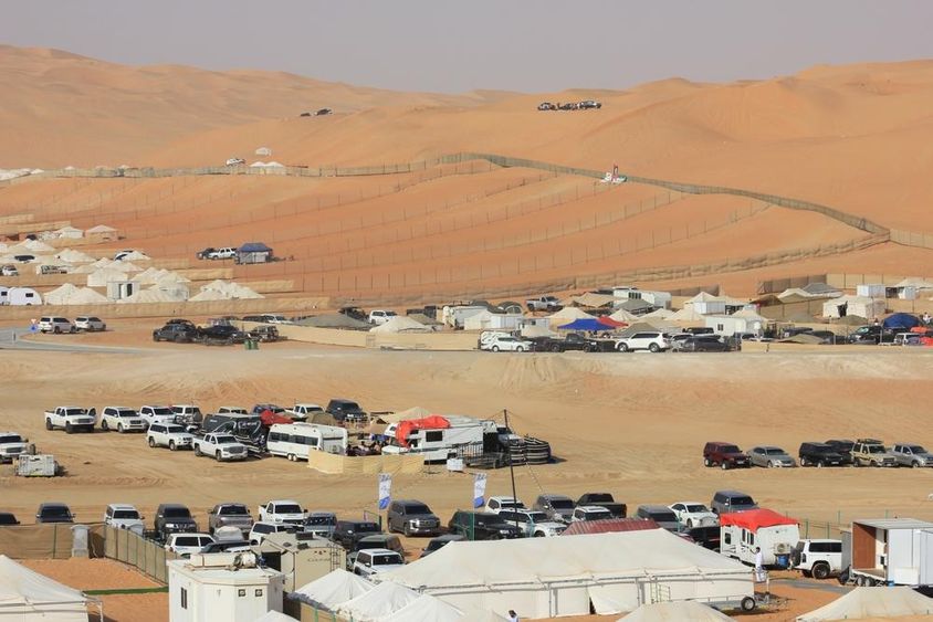 Liwa International Festival látkép a sivatagban, autókkal, lakókocsikkal és sátrakkal. 
