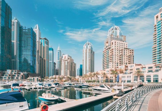 Dubai látkép a marinán kikötővel a vízen hajók ringatoznak mögötte felhőkarcolok. 