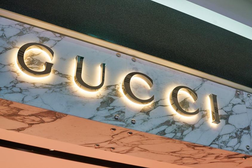 Gucci felírat látszik világító betűkből egy fal homlokzatán. 