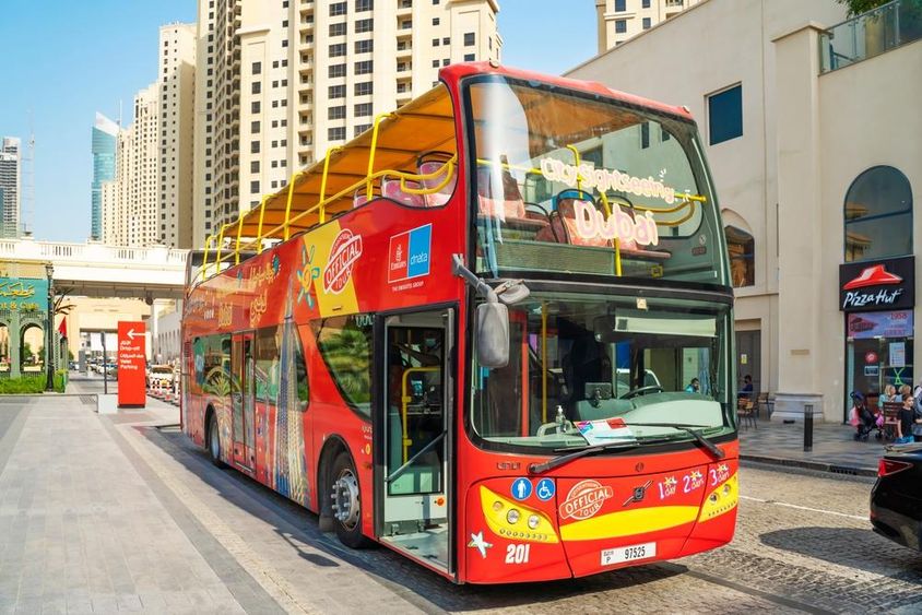 Dubai On & Off Bus with skyscrapers in the background.