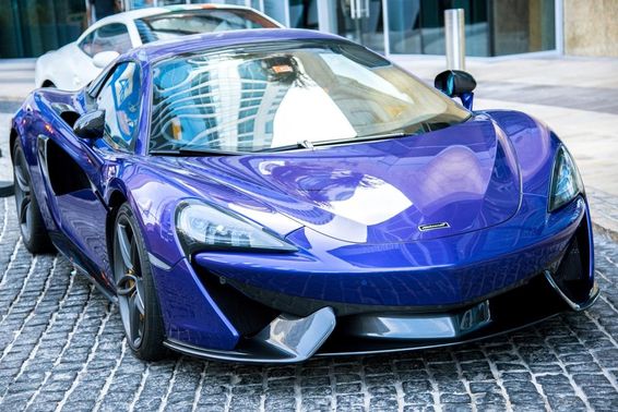Kék McLaren autó parkol egy Dubai utcán. 