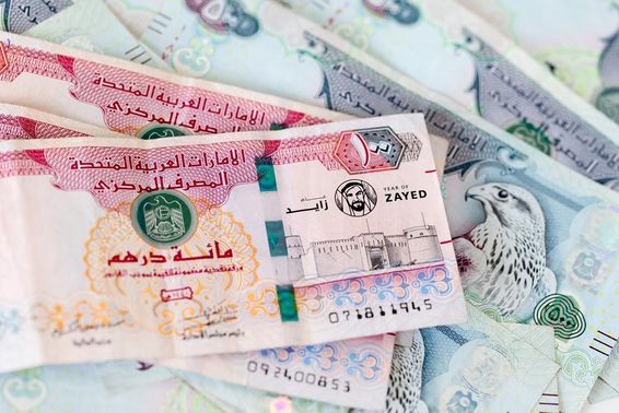 UAE dirham bankjegyek egymás hegyén hátán. 