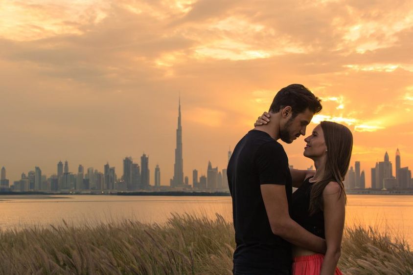 Fiatal pár, mögöttük Dubai látkép. 