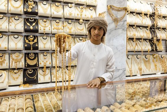 Arab fiú aranyat mutat egy boltban. 