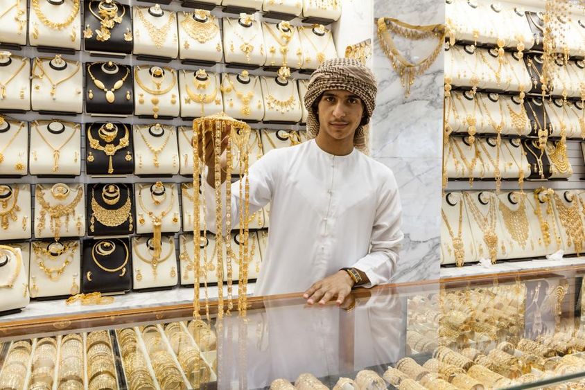 Arab boy displays gold in a shop.