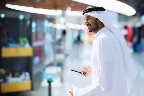 Dubai reptéren egy arab férfi kezében telefon. 