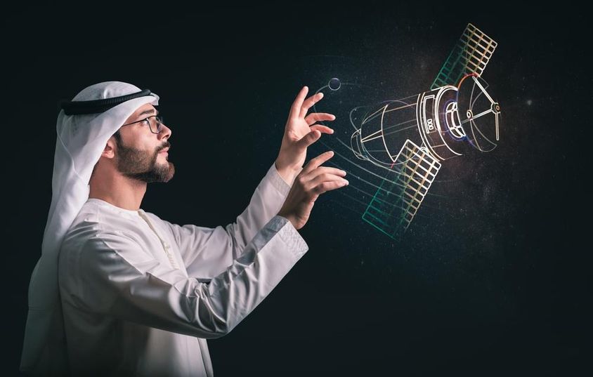 Hombre musulmán frente a satélite proyectado.