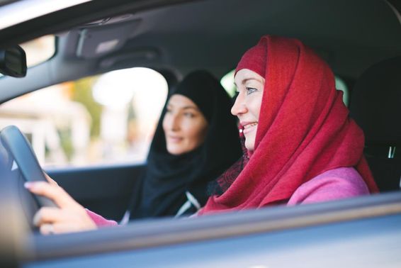 穆斯林女性开车，载着另一位穆斯林女性。