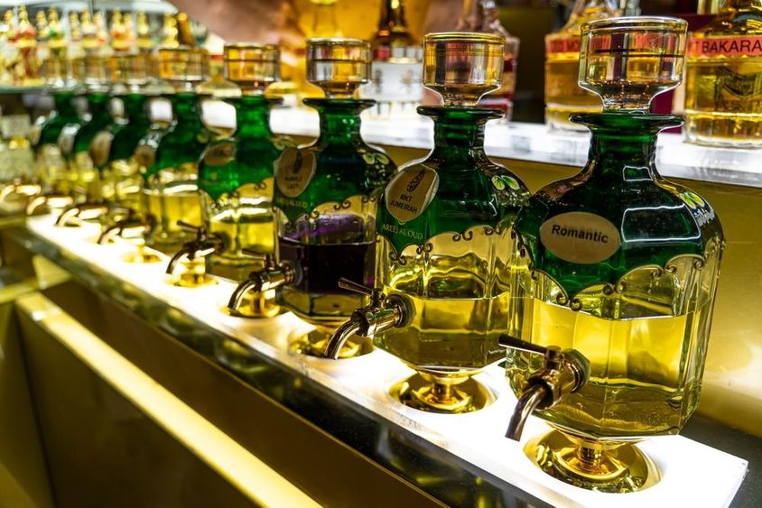 Közelkép a parfümkészítéshez használt illóolajos palackokról, amelyek a Souk Madinat Jumeirah piacon sorakoznak.