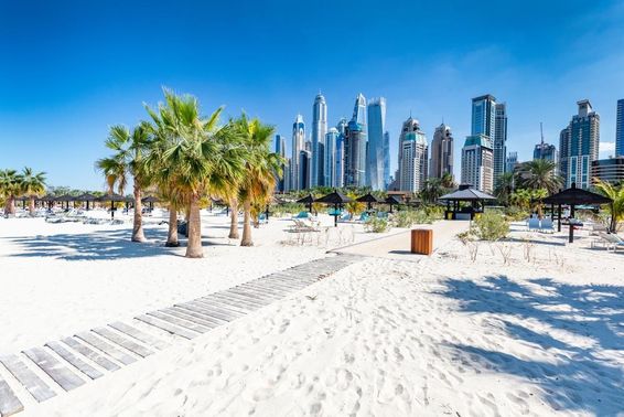 Praia de Jumeirah em Dubai ao fundo com arranha-céus em Dubai.