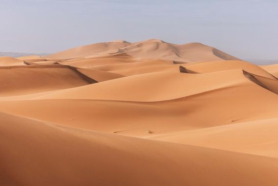 Dunas imponentes, pôr do sol dourado sobre uma paisagem calma e silenciosa.