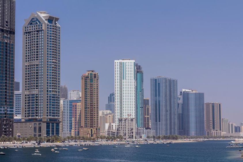 Sharjah felhőkarcolói sorakoznak a vízparton. 