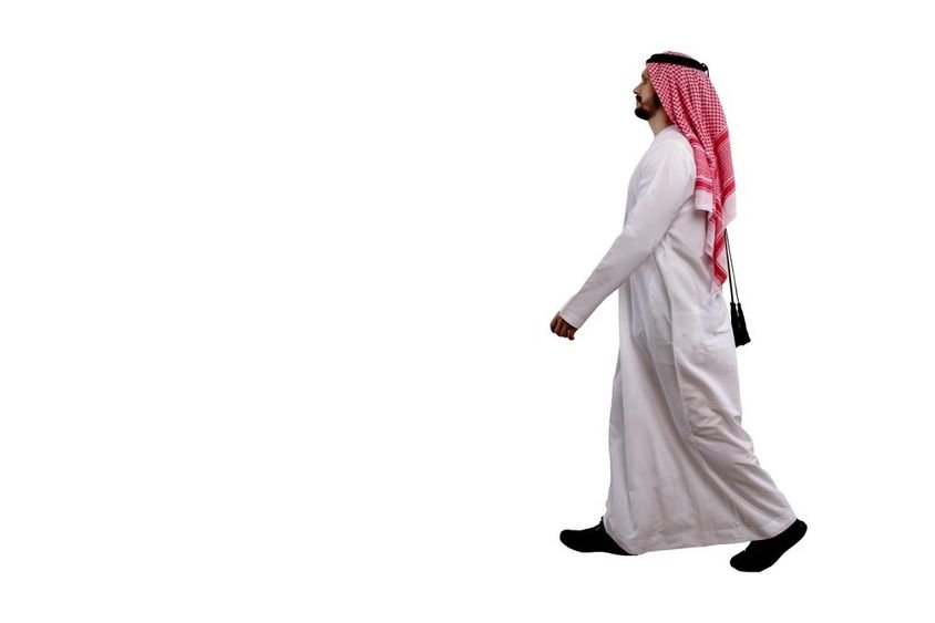 Arab férfi sétál népviseletben.