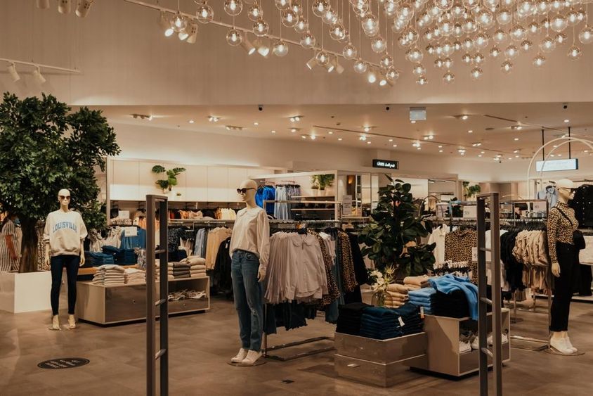 Magasin de détail de Dubaï avec de nombreux vêtements et mannequins.