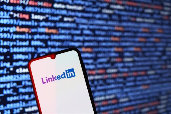 Okostelefon  LinkedIn logó látható, háttérben kódrészlet fut. 