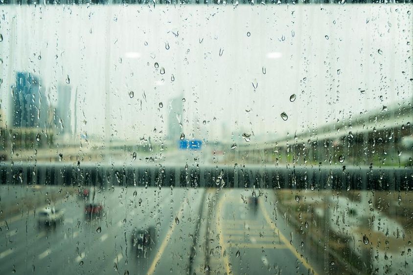 Raindrops on a glass window after heavy rainfall in Dubai.