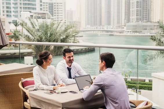 Üzleti találkozó a modern erkélyen Dubai Marinan.