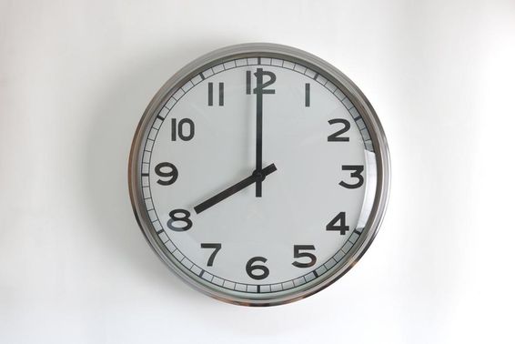 Kerek alakú, rozsdamentes acél falióra fehér számlappal.