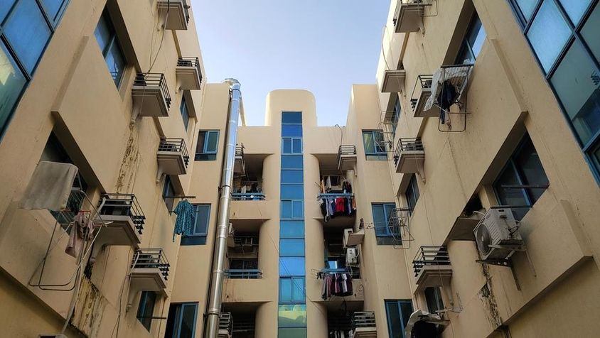 Dubai olcsó lakószoba bérelhető épület erkélye légkondicionálással és ruhákkal.
