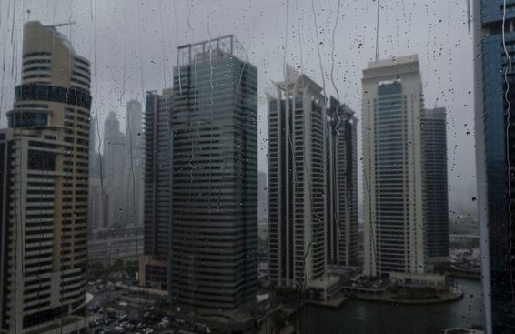 Janela molhada mostrando o moderno horizonte comercial de Dubai.