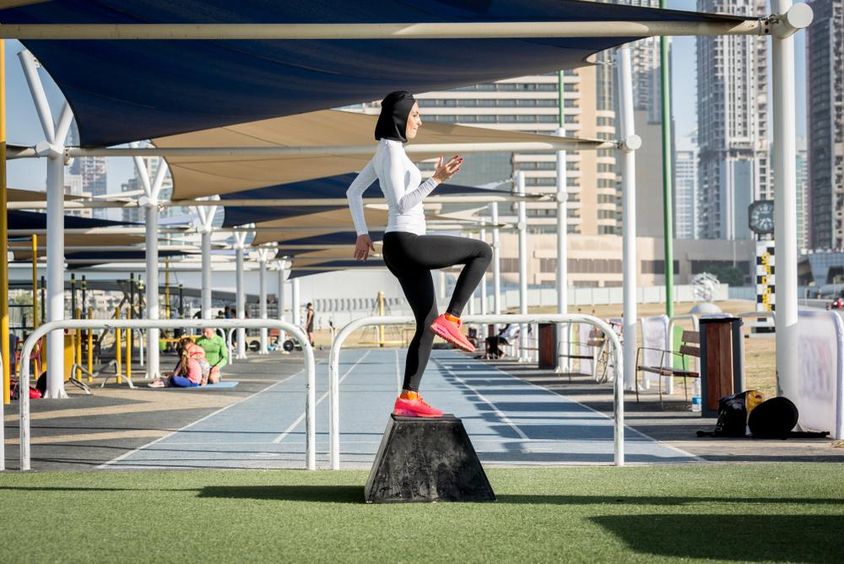 Arab nő sportol, hidzsábot visel.