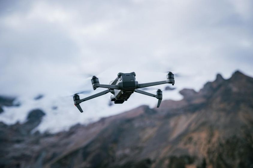 Drone flying over a high-altitude mountain top.