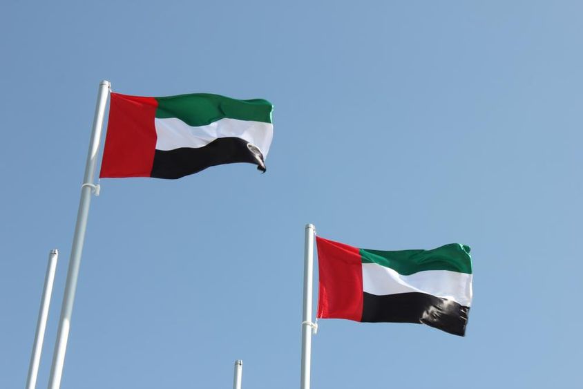 Az Egyesült Arab Emírségek zászlói lobognak a szélben.