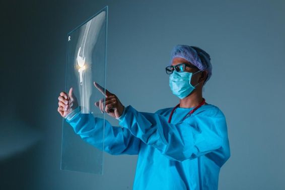 Doctor holding patient's bone X-ray image before surgery.