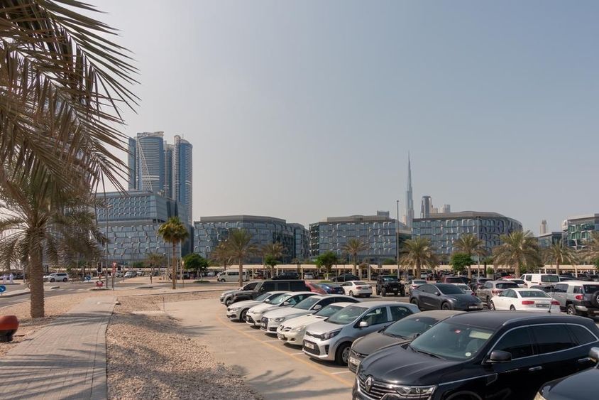 View of Dubai's modern office buildings in the design district from the parking area.