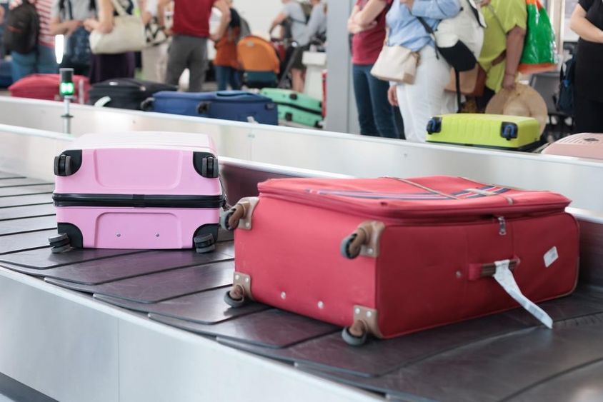 Bőröndök egy poggyászfutópályán a Dubai repülőtéren egy forgalmas utazási napon.