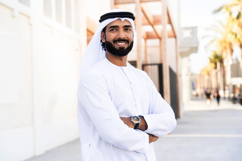 Hagyományos arab férfi emírségi kandura ruhát visel a szabadban.