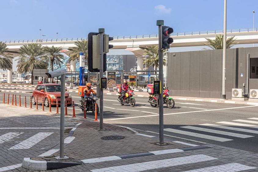 Sheikh Zayed úton három motorkerékpár és egy autó áll meg a gyalogátkelőhelyen.