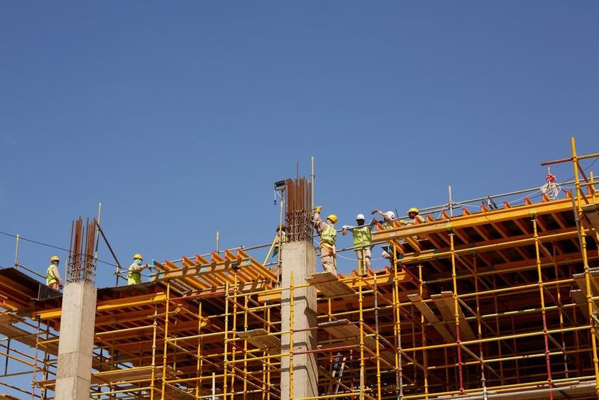 Abu Dhabi, építőipari munkások toronyházakat építenek.
