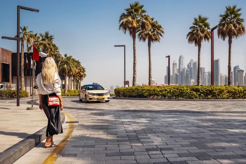 Dubaiban egy nő áll az utcán, taxira várva.