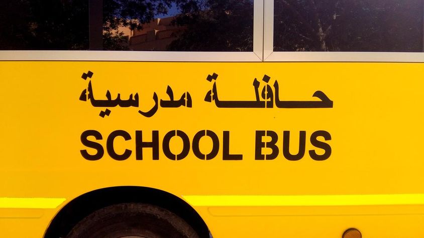 Egy busz oldalán, az iskolabusz arab felirattal.