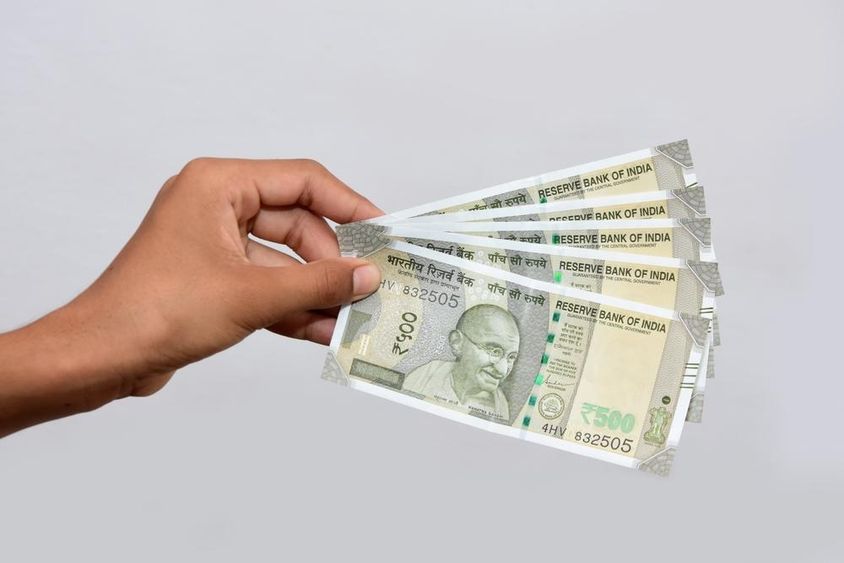Egy ember kezében tart indiai új valuta 500 rúpiás (500 rúpia) bankjegyeket.