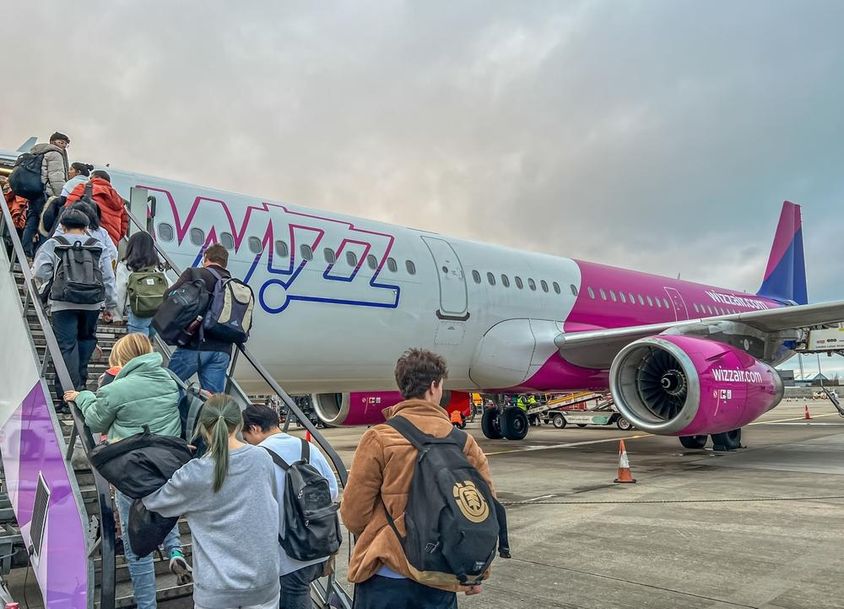 Hátizsákos utasok szállnak fel a Wizz Air légitársaság repülőgépére