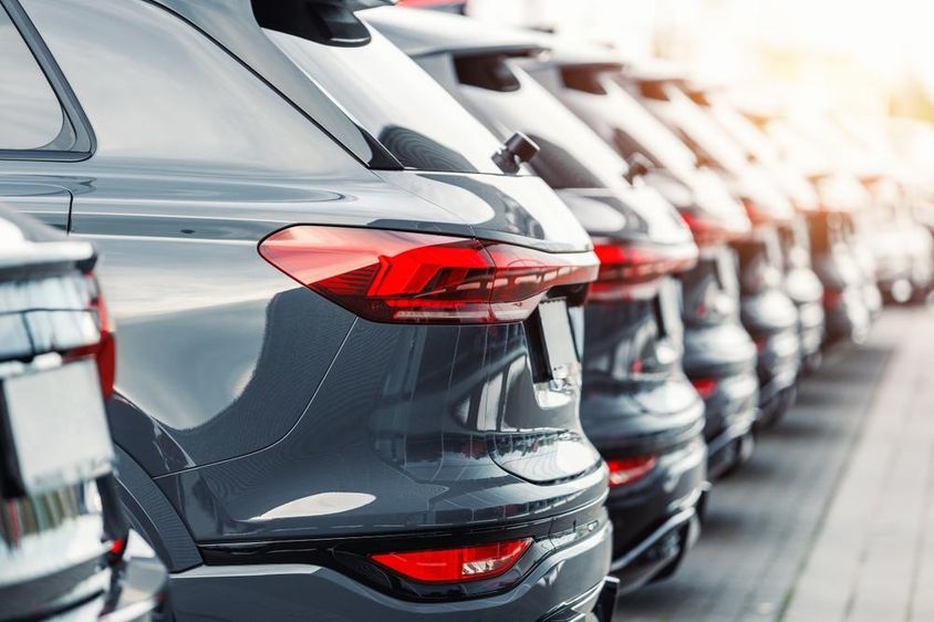 Hátulnézetből sok modern új SUV autó flotta készlet a kereskedés parkolójában.
