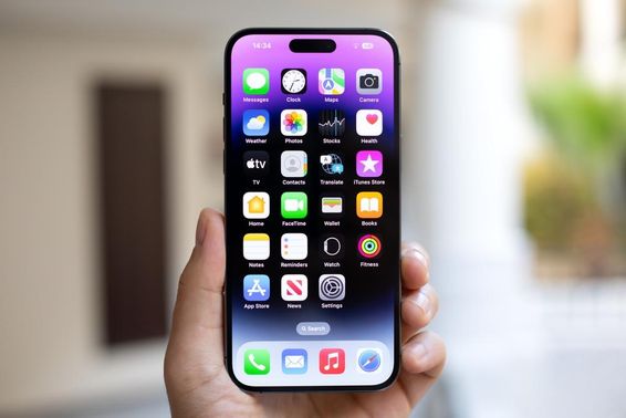 Man holding an iPhone 15 Pro Max with iOS 17 on screen.