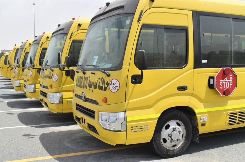Több sárga iskolabusz sorakozik fel egy parkolóban Dubaiban.