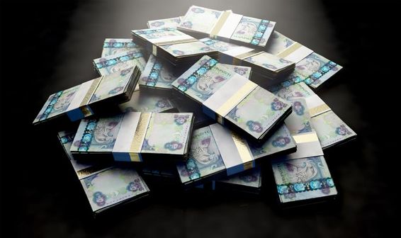 Egy halom véletlenszerűen szétszórt dirham bankjegyköteg.