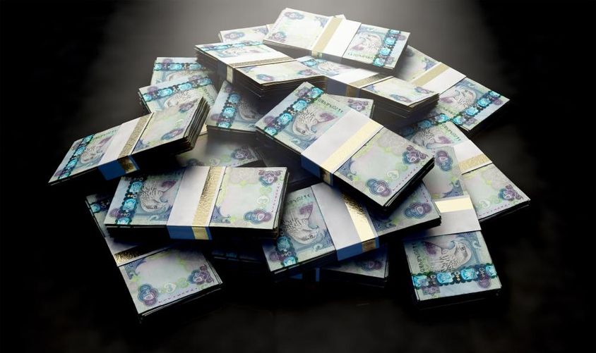 Egy halom véletlenszerűen szétszórt dirham bankjegyköteg.