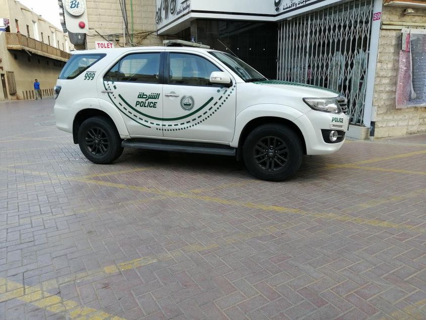 Egy dubaji rendőrautó oldalnézete egy utcában.