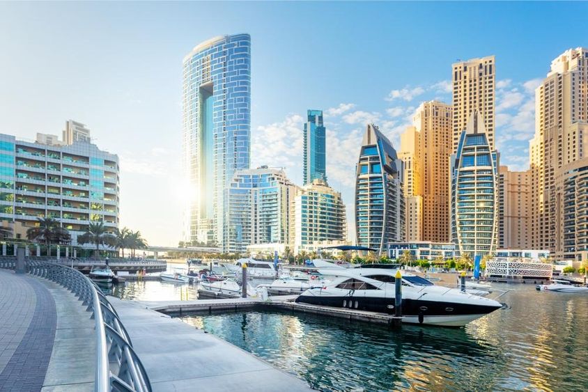 Gyönyörű kilátás nyílik a Dubai Marinara modern épületekkel és jachtokkal a vízen.